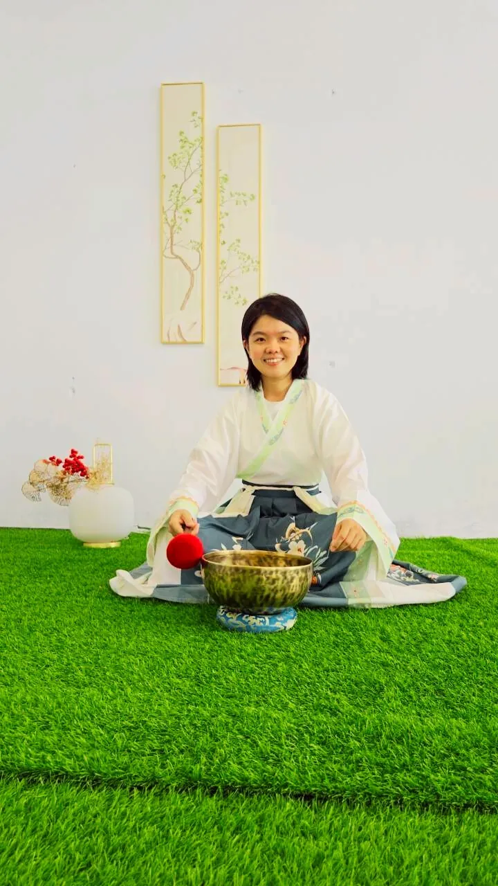 流星老師盤坐在草地上，面前放著頌缽